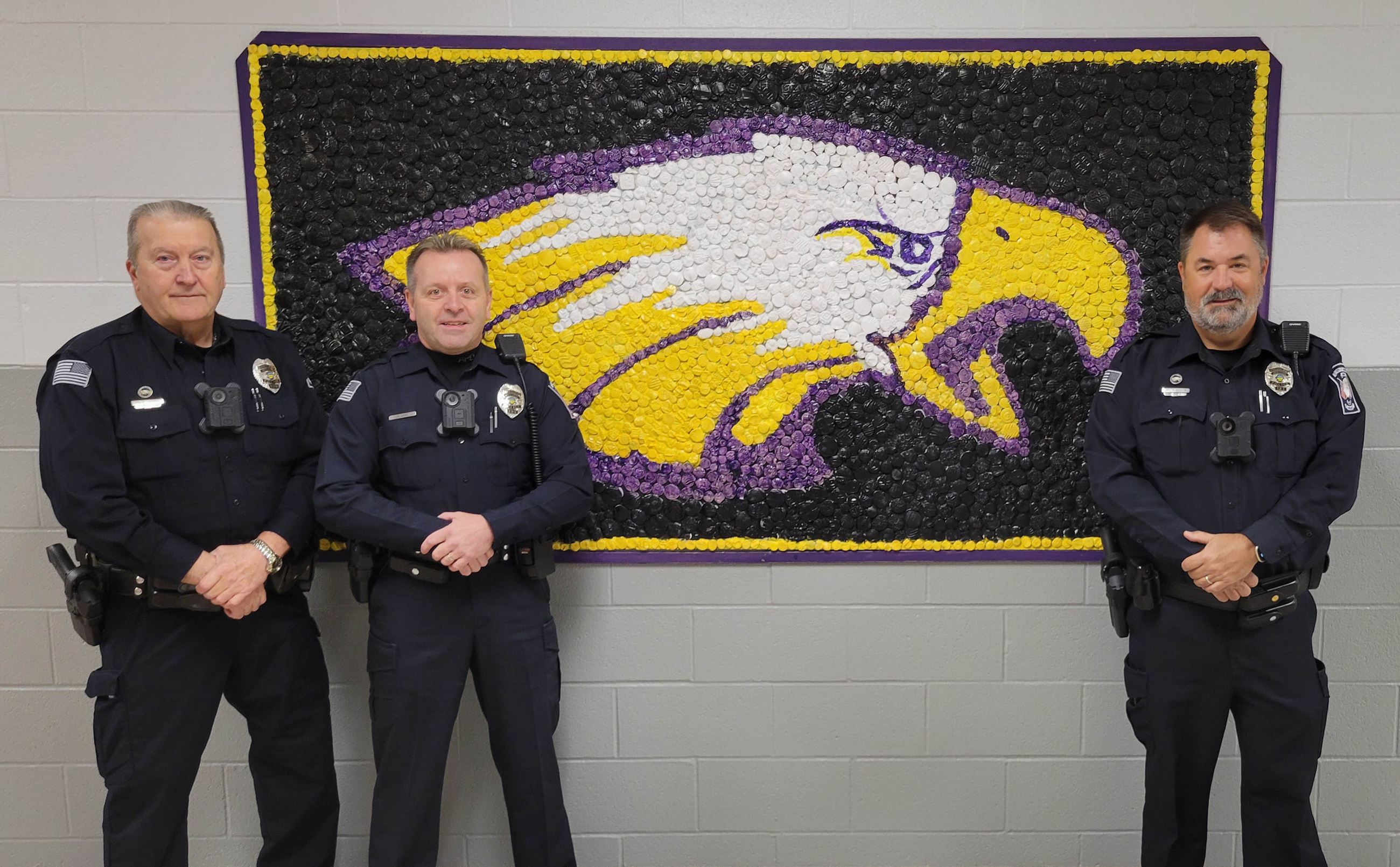 School Resource Officers standing in front of the Avon School District logo